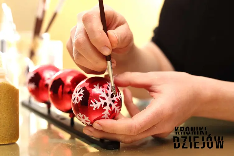 Kobieta tworzy ozdobny wzór na świątecznej bombce, ręcznie malowane bombki na choinkę, skąd zrodziła się tradycja zawieszania bombek na choinkę