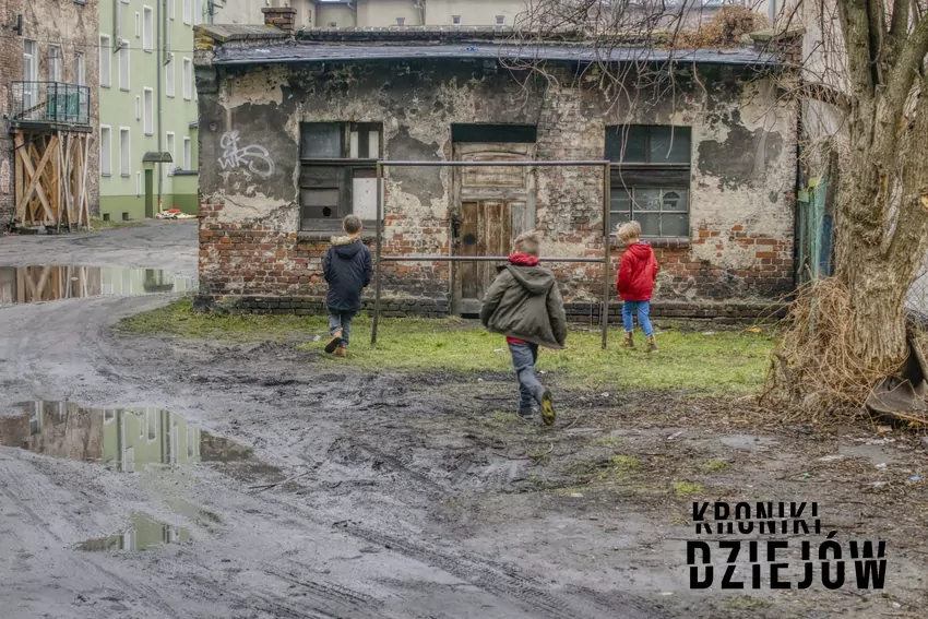 Gromadka dzieci na zabłoconym podwórku przy trzepaku, czyli jak kiedyś bawiły się dzieci