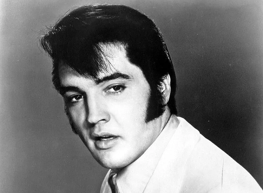 Elvis Presley u szczytu swojej kariery na czarno-białym zdjęciu, a także 10 najlepszych piosenek Elvisa Presleya
