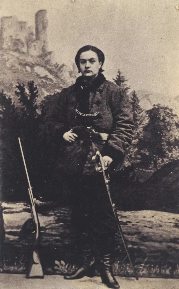 Słynne zdjęcie Pustowójtówny w kożuchu żołnierskim i oficerkach wykonano w Pradze (domena publiczna) Pustowójtówna w kożuchu, oficerkach i z bronią u pasa - zdjęcie pozowane