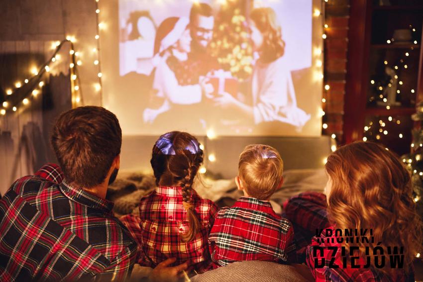Rodzina siedzi w domu przed telewizorem w świątecznej scenerii, kultowe świąteczne filmy, filmy o bożym narodzeniu, filmowe hity na boże narodzenie